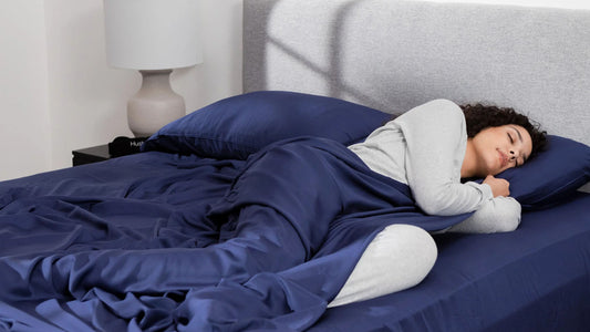 Woman sleeping under navy blue Hush sheets