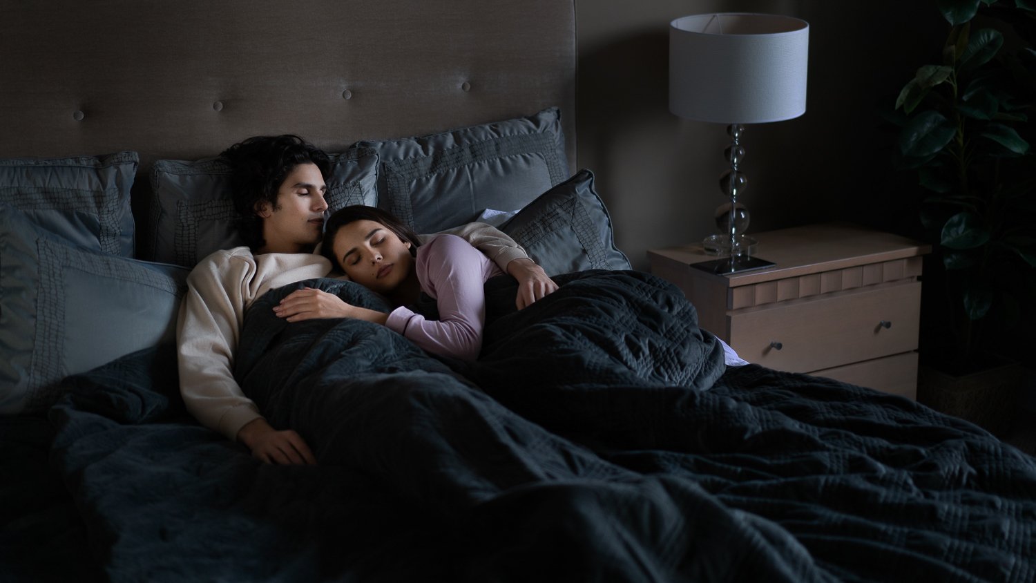 man and woman sleeping under a weighted blanket