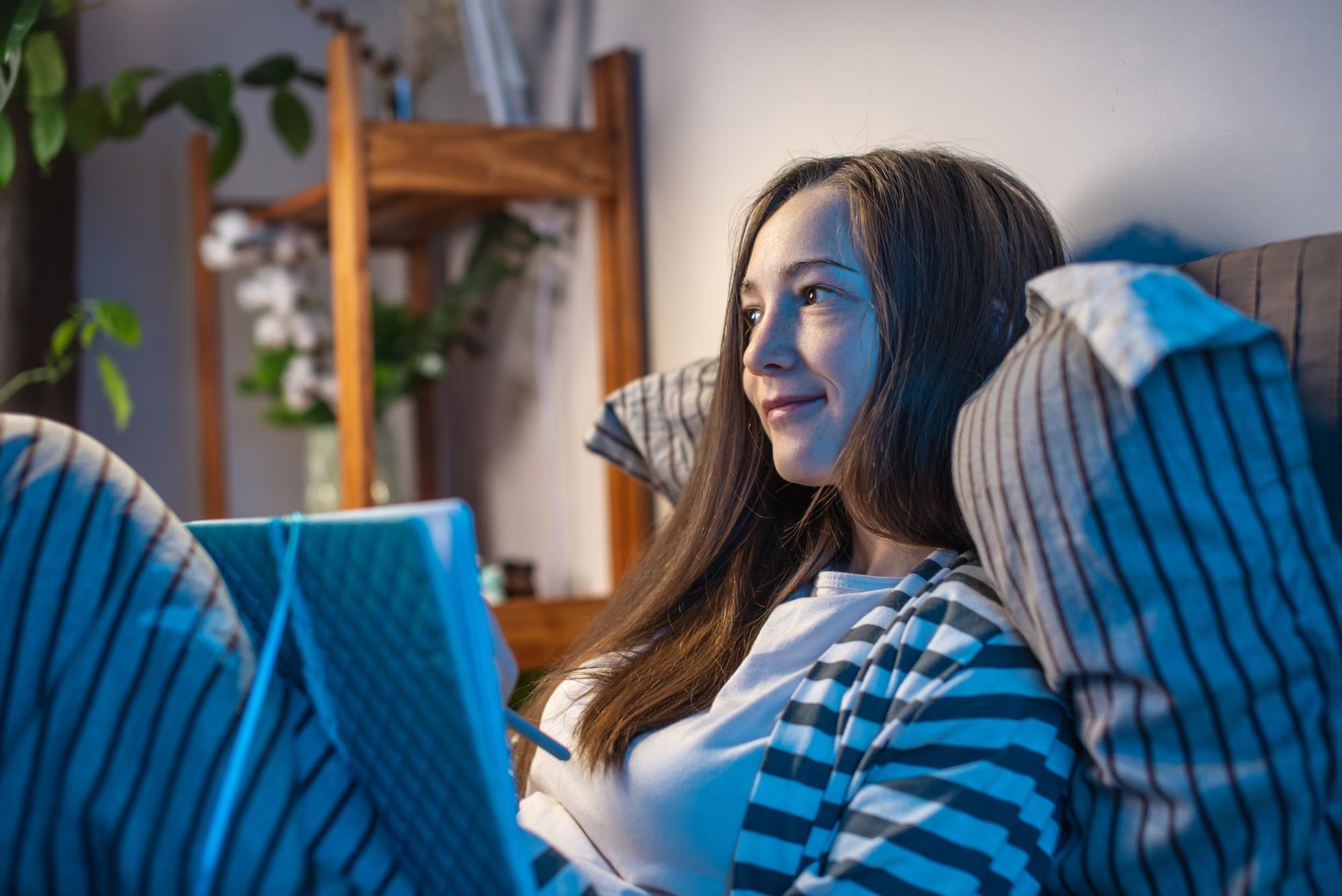 night routine: Woman writing in her notebook while in bed