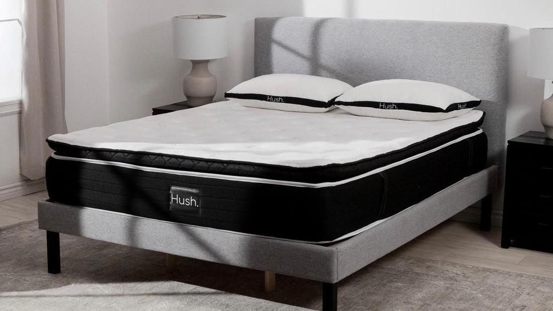 The Hush Mattress with two pillows placed in a grey bed frame.