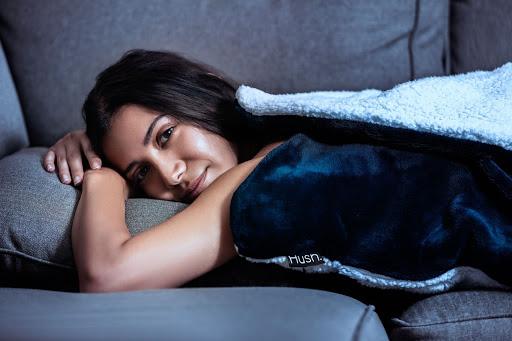 sleep solutions: women with a weighted blanket on the couch