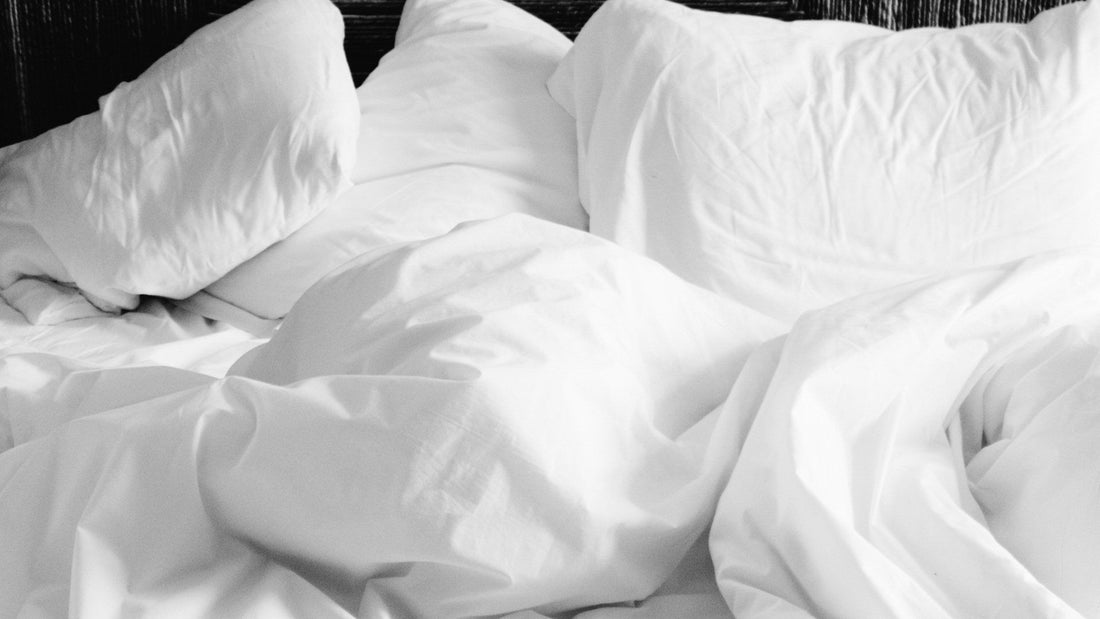 White pillows and sheets scattered on a bed.