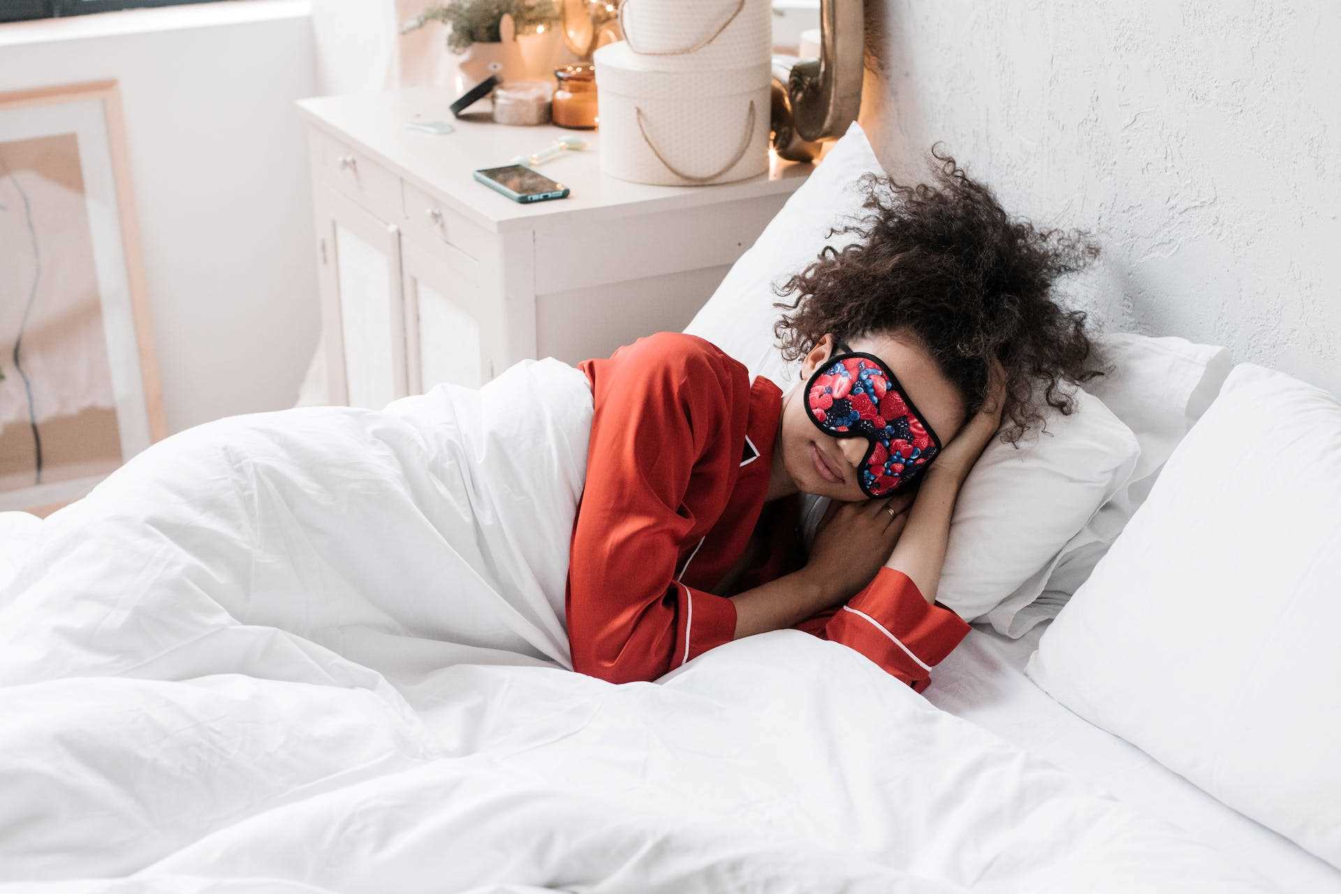 a woman sleeping in bed covered with white comforter