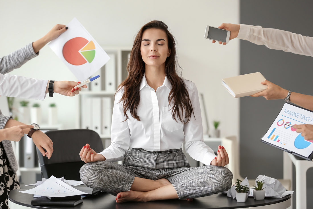 how to relax after work: Woman meditating on a table while being pressured by her colleagues