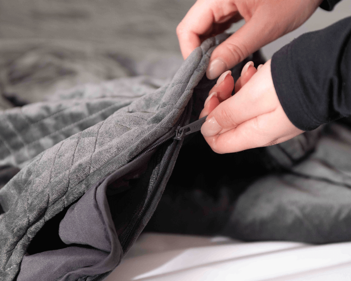 woman zipping weighted blanket cover