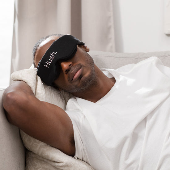 Man napping on couch with Hush Blackout Eye Mask